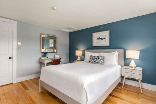 guestroom with teal wall behind bed